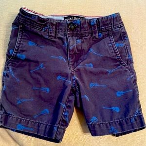 Mini Boden navy blue chino shorts with blue guitars scattered around. Size 4y